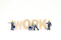 Work word from wooden letters and miniature worker on white background. Blue collar work concept scene. Royalty Free Stock Photo