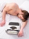 Workaholic concept. Why author use manual typewriter daily work. Man writer sleep bed white bedclothes while worked on