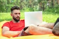 Workaholic man working on laptop during vacation, remote work. Freelancer in nature background Royalty Free Stock Photo