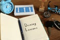 Workbook for driving lessons, pen and car key on wooden table, closeup. Passing license exam Royalty Free Stock Photo