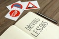 Workbook for driving lessons, pen and road signs on wooden table, closeup. Passing license exam Royalty Free Stock Photo