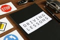 Workbook for driving lessons, pen and road signs on wooden table, closeup. Passing license exam Royalty Free Stock Photo