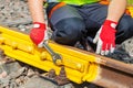 Worker with adjustable wrench fixing nut on railway track Royalty Free Stock Photo