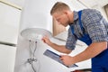 Worker Adjusting Temperature Of Water Heater Royalty Free Stock Photo