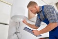 Worker Adjusting Temperature Of Water Heater