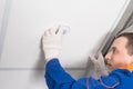 A worker adjusts a lamp in a false ceiling, close-up Royalty Free Stock Photo
