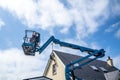 Worker on a aerial access platform, cherry picker, cleaning house