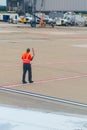 Worker at the Airport Dressing a Red Safety Jacket