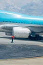 Worker at the Airport wearing a Red Jacket on Blur Background