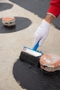 Worker applies bitumen mastic on the foundation