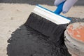 Worker applies bitumen mastic on the foundation