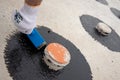 Worker applies bitumen mastic on the foundation