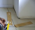 worker applies glue on wooden skirting board