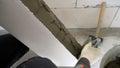 A worker applies mortar to a block to build a wall. A builder applies concrete mortar to a cinder block. A worker Royalty Free Stock Photo