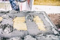 Worker applying adhesive material and mortar on insulation panel of material wool used for building facades