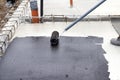 Worker applying a bituminous primer on a Concrete Slab Before Waterproofing Royalty Free Stock Photo