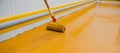 Worker applying epoxy and polyurethane flooring system Royalty Free Stock Photo