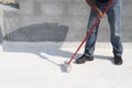 Worker applying white roof coating Royalty Free Stock Photo