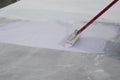 Worker applying white roof coating Royalty Free Stock Photo