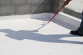 Worker applying white roof coating Royalty Free Stock Photo