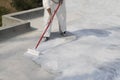 Worker applying white roof coating Royalty Free Stock Photo
