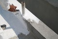 Worker applying white roof coating Royalty Free Stock Photo