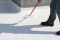 Worker applying white roof coating Royalty Free Stock Photo