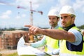 Worker and architect watching some details on a construction