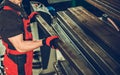 Worker Arranging Metal Square Tubes in Workshop