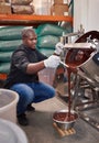 Confectionary factory worker pouring melting chocolate into a bowl Royalty Free Stock Photo