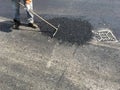 Worker asphalt a road in summer