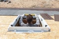 Worker on a asphalt shingle roof installing new plastic mansard or skylight window. Royalty Free Stock Photo