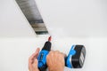 Worker assemble a suspended ceiling and fixing panel with an screwdriver Royalty Free Stock Photo