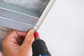 Worker assemble a suspended ceiling and fixing panel with an screwdriver Royalty Free Stock Photo