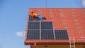 A worker assembles solar panels on the roof of a house, in Uzhgorod, Ukraine.