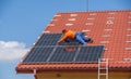 A worker assembles solar panels on the roof of a house, in Uzhgorod, Ukraine.