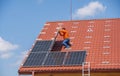 A worker assembles solar panels on the roof of a house, in Uzhgorod, Ukraine.