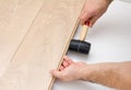 Worker assembling laminate floor using a hammer Royalty Free Stock Photo