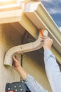 Worker Attaching Aluminum Rain Gutter and Down Spout to Fascia o