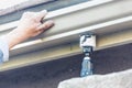 Worker Attaching Aluminum Rain Gutter to Fascia of House