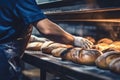 A worker in a bakery puts bread in the oven. Bread production enterprise. Bakery. Close-up