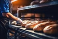 A worker in a bakery puts bread in the oven. Bread production enterprise. Bakery. Close-up