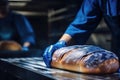 A worker in a bakery puts bread in the oven. Bread production enterprise. Bakery. Close-up