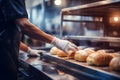 A worker in a bakery puts bread in the oven. Bread production enterprise. Bakery. Close-up