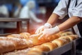 A worker in a bakery puts bread in the oven. Bread production enterprise. Bakery. Close-up