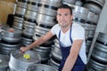 Worker with beer barrels at brewery Royalty Free Stock Photo