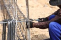 Worker bending steel rod for construction job