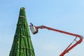 Worker on big crane during install and decoration ornament the christmas tree