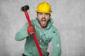 A worker with a big hammer screams like a possessed man