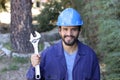 Worker with blue protective hat holding adjustable wrench Royalty Free Stock Photo